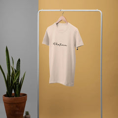 White t-shirt with 'Whatever' text on a white rack against a yellow wall.