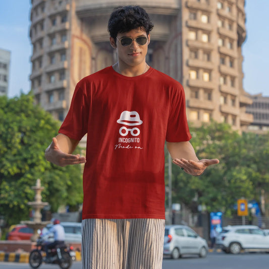 Person wearing a red t-shirt with a logo in front of a building
