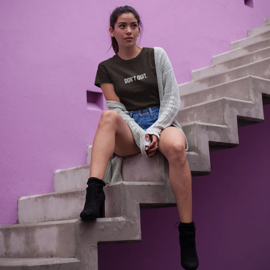 Woman sitting on a staircase against a purple wall