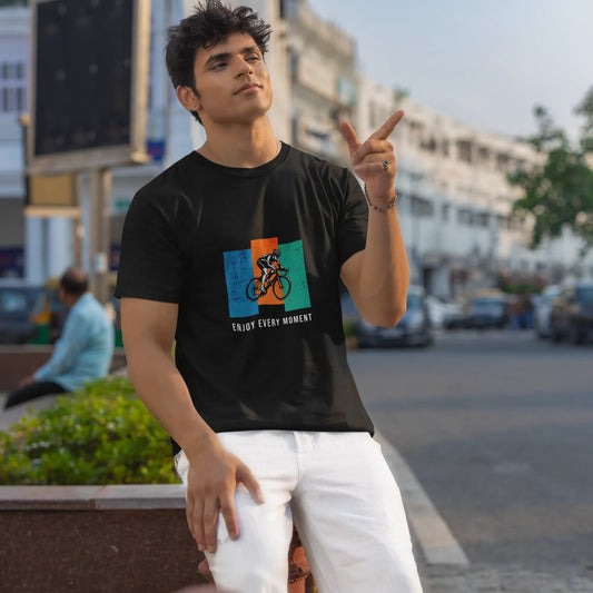 Man wearing a black t-shirt with a colorful graphic design on a city street.