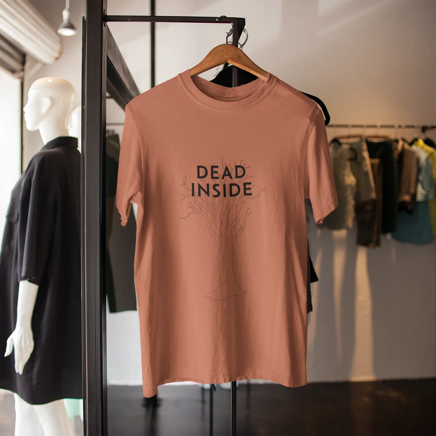 Brown t-shirt with 'DEAD INSIDE' text on a hanger in a store setting