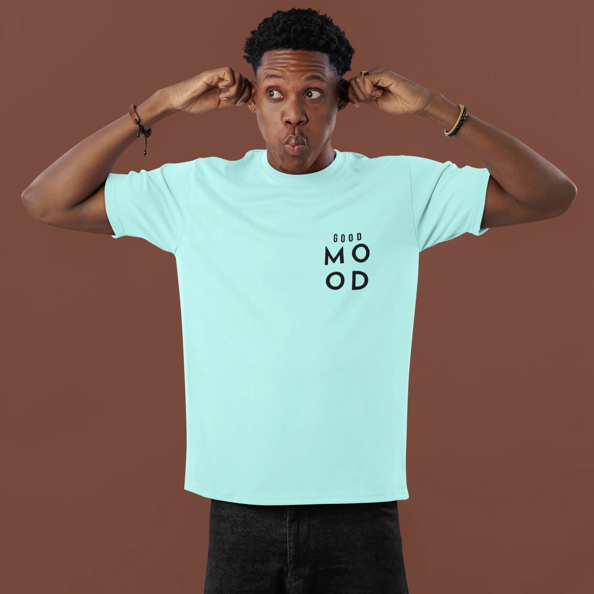 Person wearing a light blue t-shirt with text on a brown background