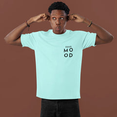 Person wearing a light blue t-shirt with text on a brown background