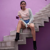 Woman sitting on a staircase against a purple wall