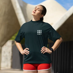 Woman wearing a dark green athletic shirt with a logo and red shorts, standing outdoors.