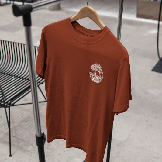 Brown t-shirt with a logo on a hanger against a neutral background
