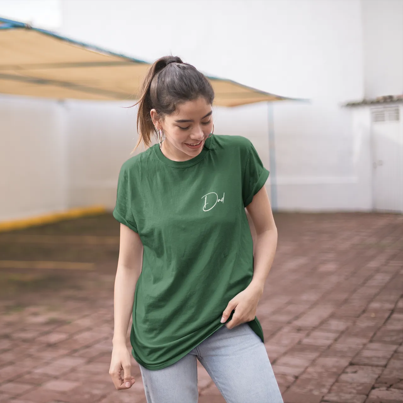 Person wearing a green t-shirt with a logo in an outdoor setting