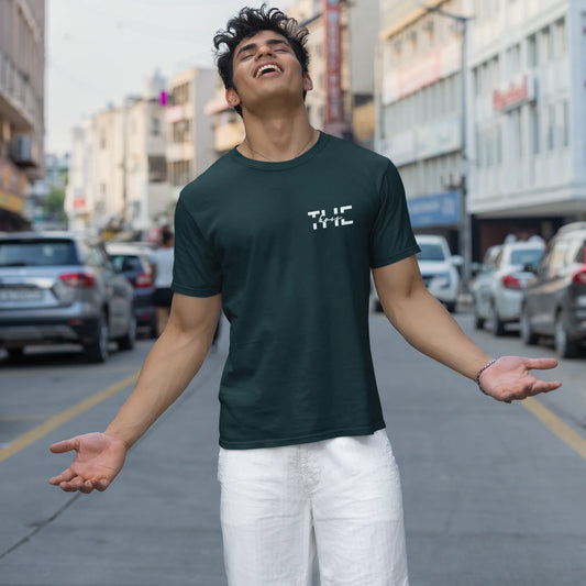 Man wearing a dark green t-shirt with text on a city street