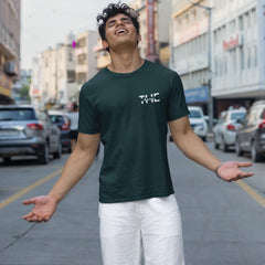 Man wearing a dark green t-shirt with text on a city street