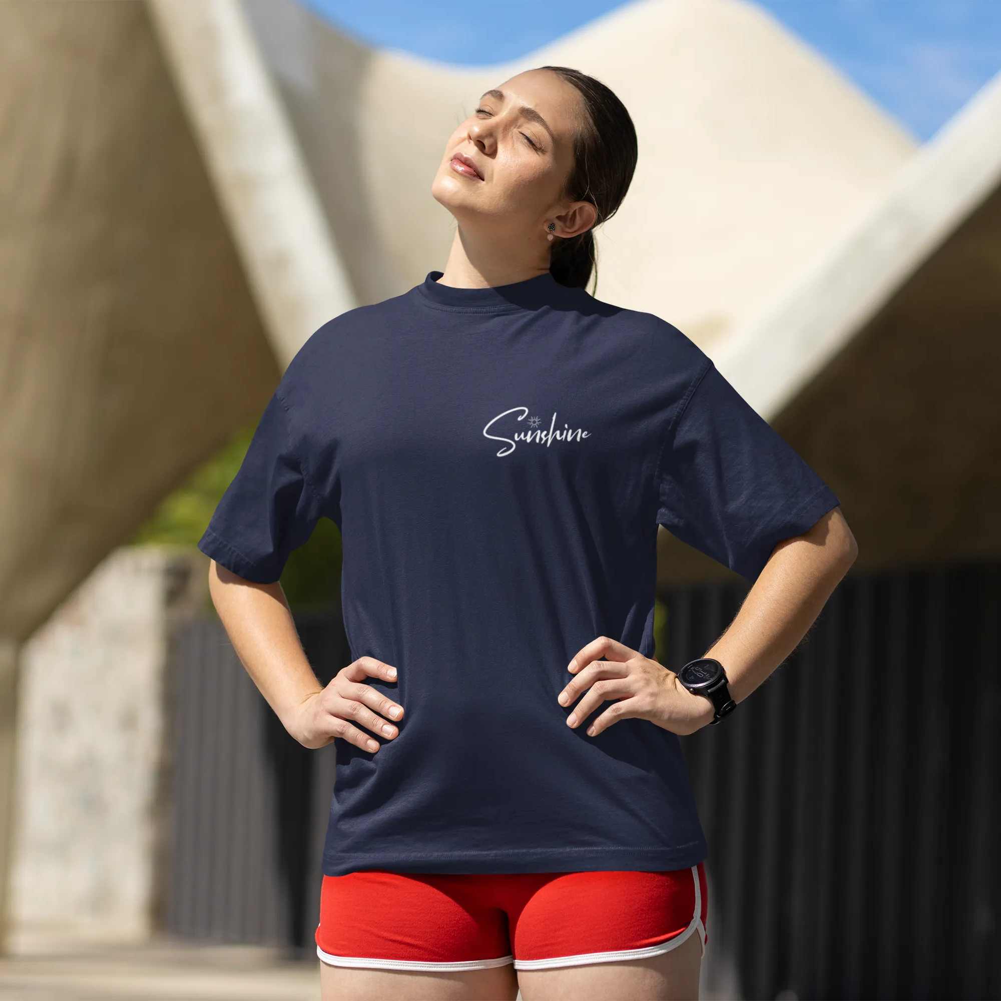 Woman wearing a navy blue shirt with 'Sambas' branding, standing outdoors.