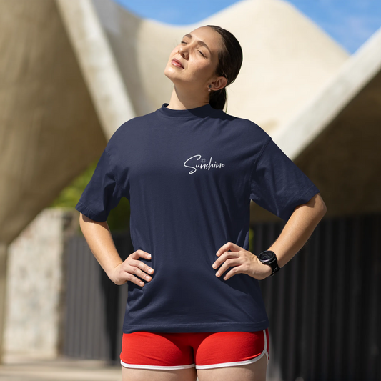 Woman wearing a navy blue shirt with 'Sambas' branding, standing outdoors.