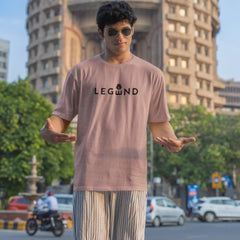 Person wearing a t-shirt with 'LEGEND' printed on it, standing in an urban setting with buildings and trees in the background.