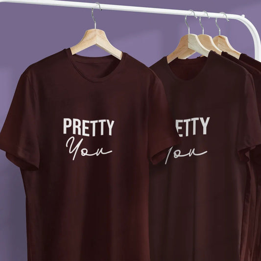 Brown t-shirts with 'PRETTY You' text on hangers against a purple background