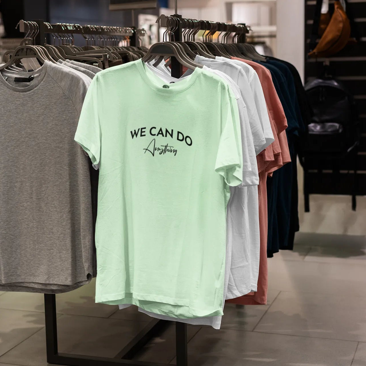 T-shirts on display in a store with 'WE CAN DO Anything' text