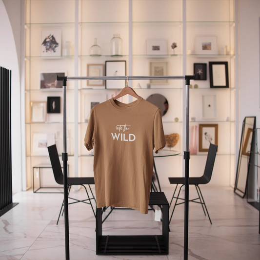 Brown t-shirt with 'Go Wild' text on a rack in a modern interior setting