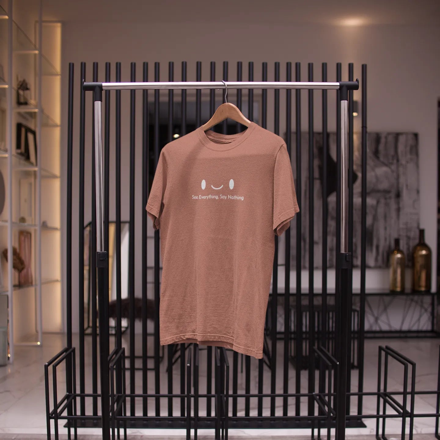 Brown t-shirt on a hanger against a black metal rack in a store setting