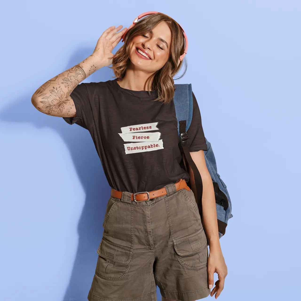 Woman wearing a black t-shirt with text, standing against a light blue background