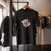 Black t-shirt with red and white text on a hanger in a clothing store.