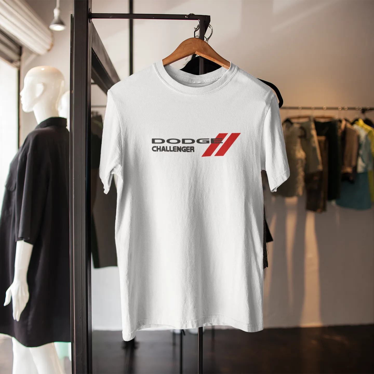 White t-shirt with 'Dodge Challenger' logo on a hanger in a store setting.