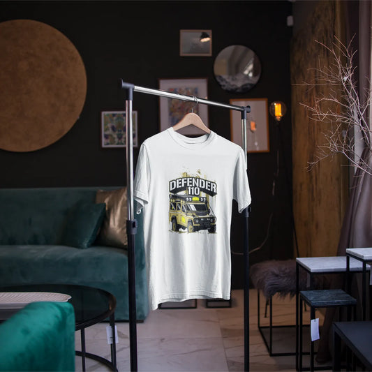 White t-shirt with graphic design on a hanger in a room with green sofa and decor elements.