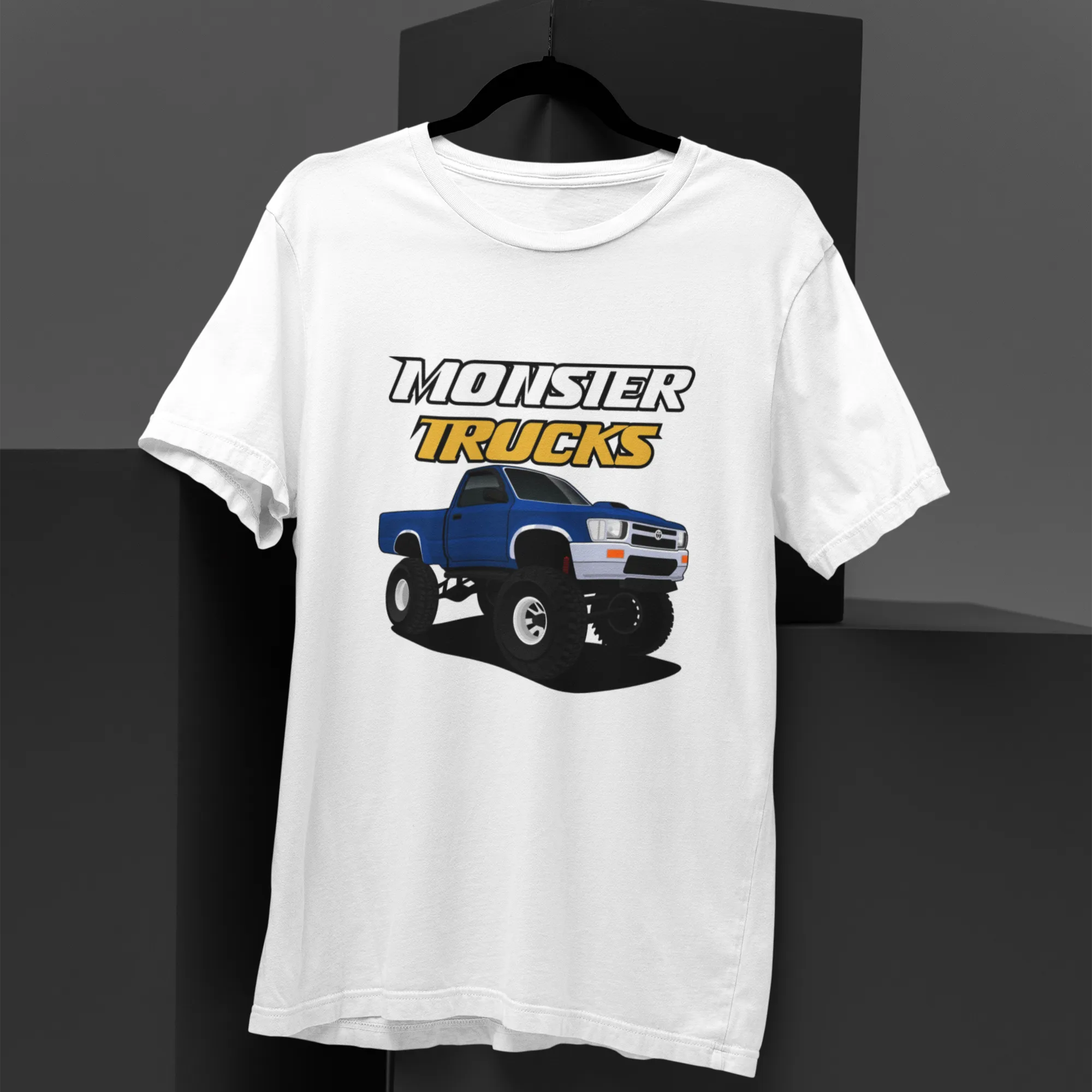 White t-shirt with monster truck graphic and text on a black background