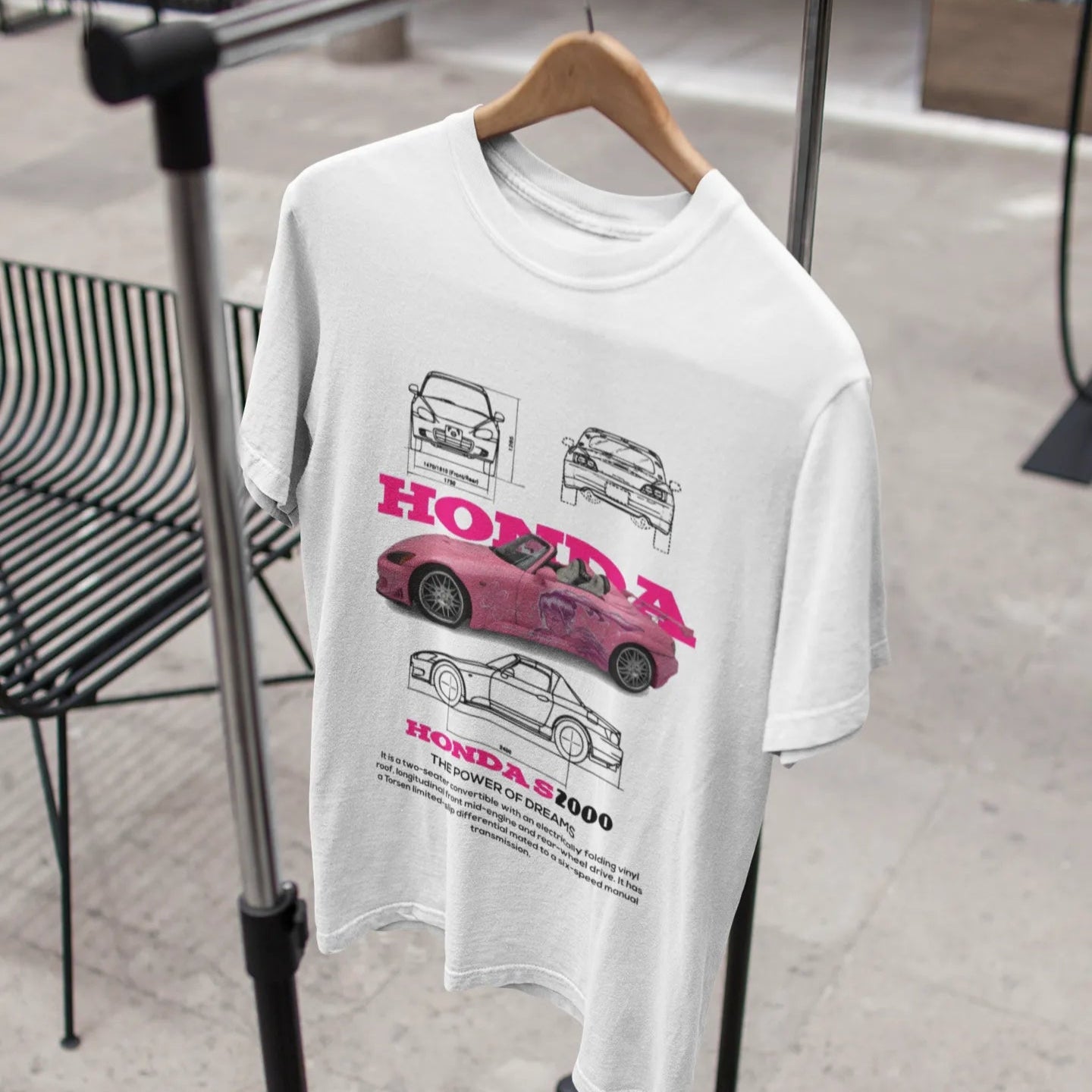 White t-shirt with car graphics on a hanger in a store setting