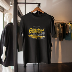 Black t-shirt with yellow graphic design on a hanger in a store setting