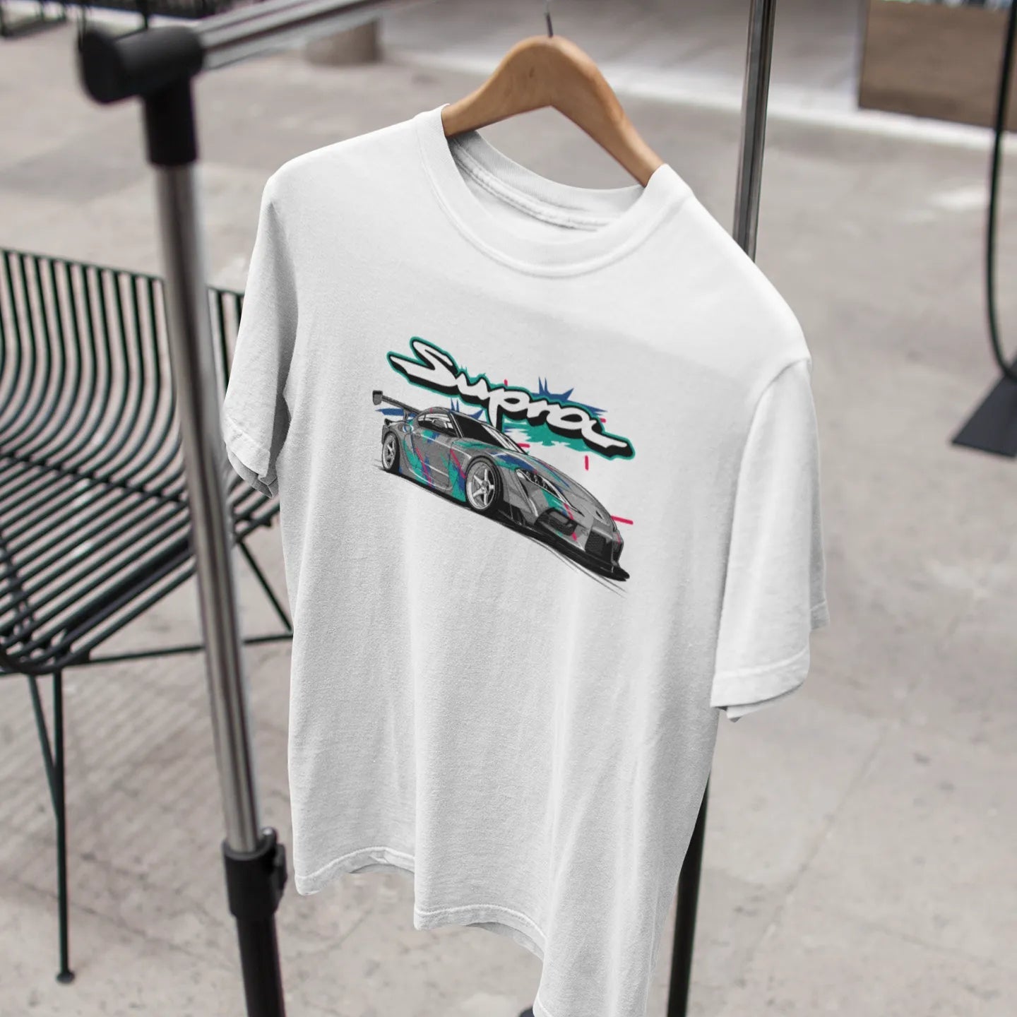 White t-shirt with a graphic design on a hanger in an indoor setting