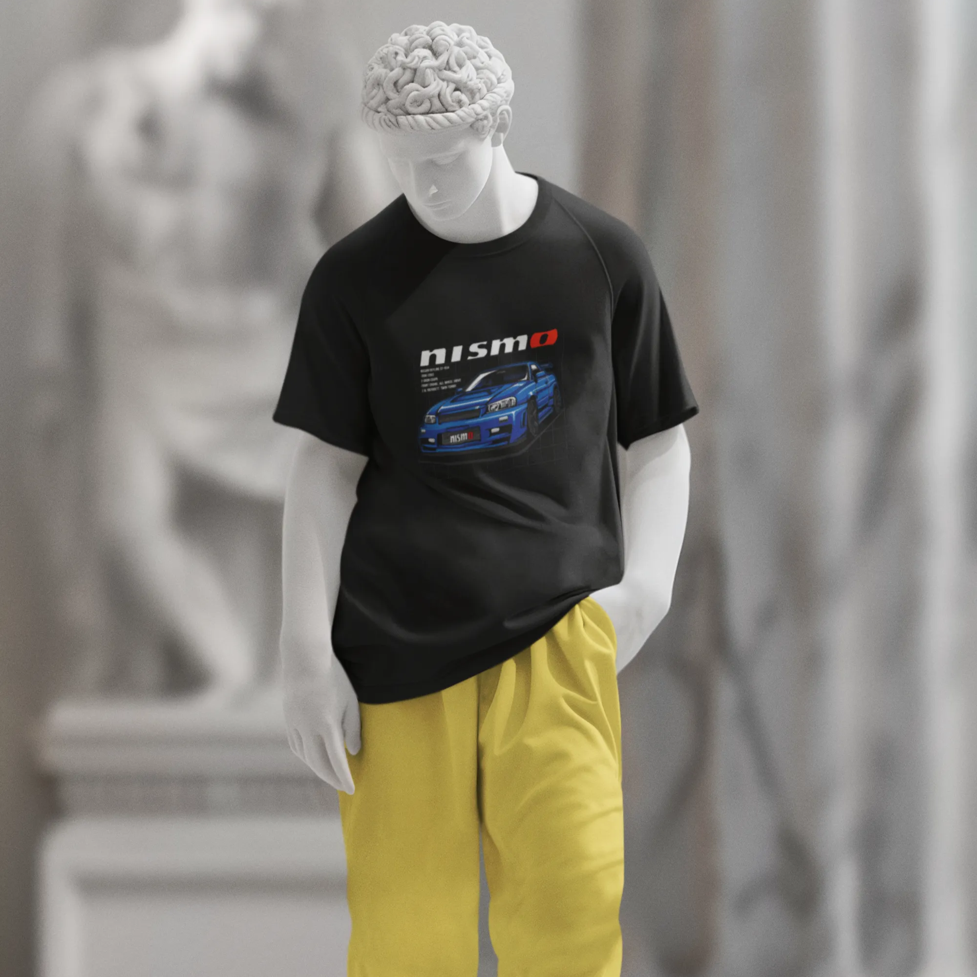 Mannequin wearing a black t-shirt with a graphic design and yellow pants in an indoor setting.
