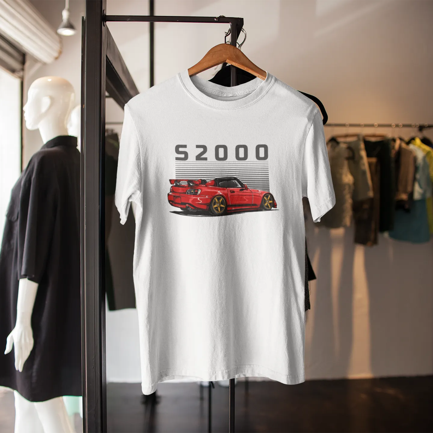 White t-shirt with red car graphic and 'S2000' text on a rack in a store setting