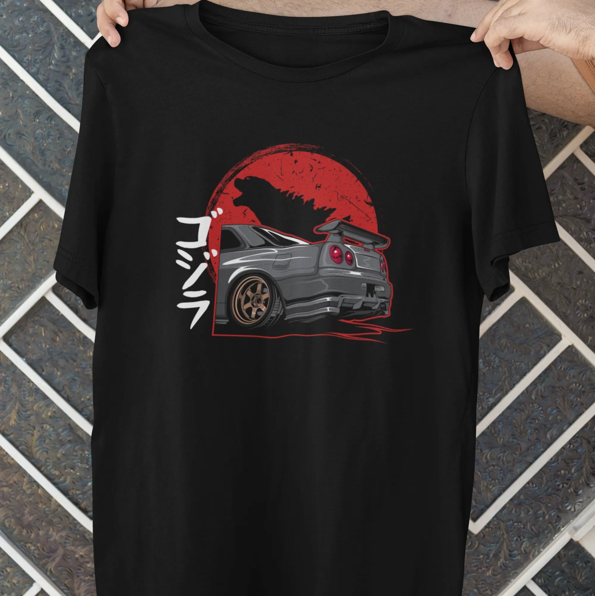 Black t-shirt with a graphic design of a car and red circle on a textured wall background