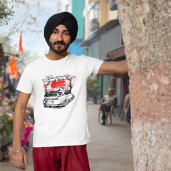 Man wearing a white t-shirt with a graphic design, standing in an outdoor market setting.