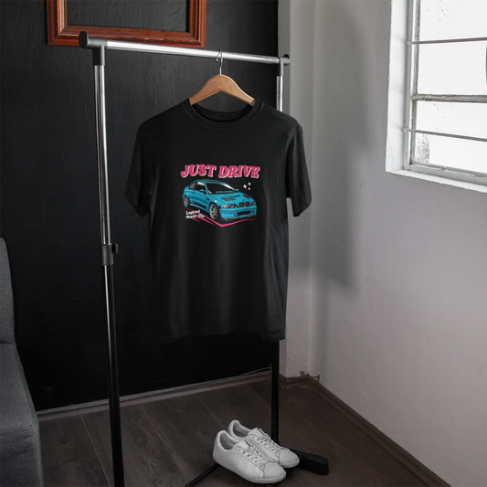 Black t-shirt with car graphic and 'Just Drive' text on a hanger in a room.