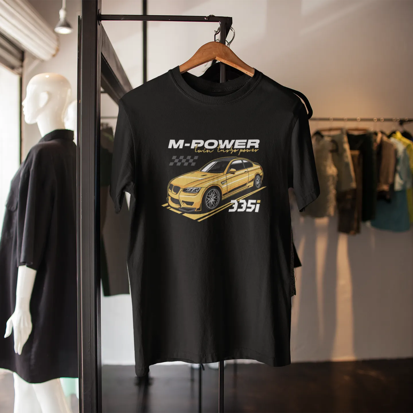 Black t-shirt with car graphic and 'M-Power' text on a mannequin in a store setting.