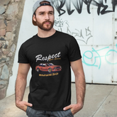 Man wearing a black t-shirt with a graphic design in front of a graffiti-covered wall.