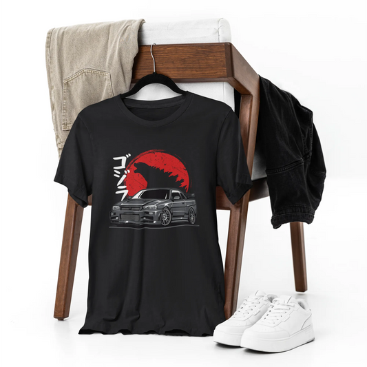 Black t-shirt with graphic design on a chair with jeans and sneakers.