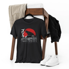 Black t-shirt with graphic design on a chair with jeans and sneakers.