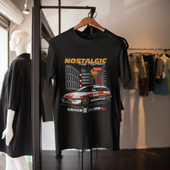 Black t-shirt with car graphic and text on a hanger in a store setting