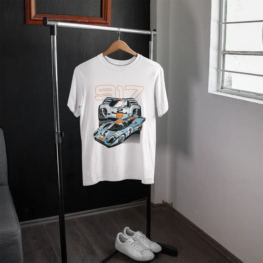 White t-shirt with car graphic on a hanger in a room with a window.