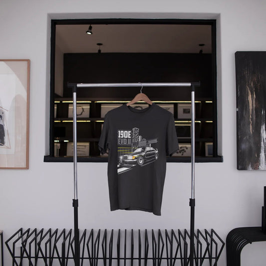 Black t-shirt with graphic design hanging on a rack in a modern interior setting.