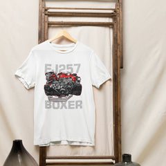 White t-shirt with engine graphic and text hanging on a wooden rack against a beige wall.