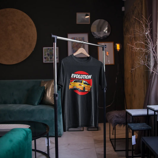 Black t-shirt with a graphic design on a hanger in a room with green sofa and wall art.