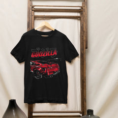 Black t-shirt with red and white graphic design on a wooden rack against a white wall.
