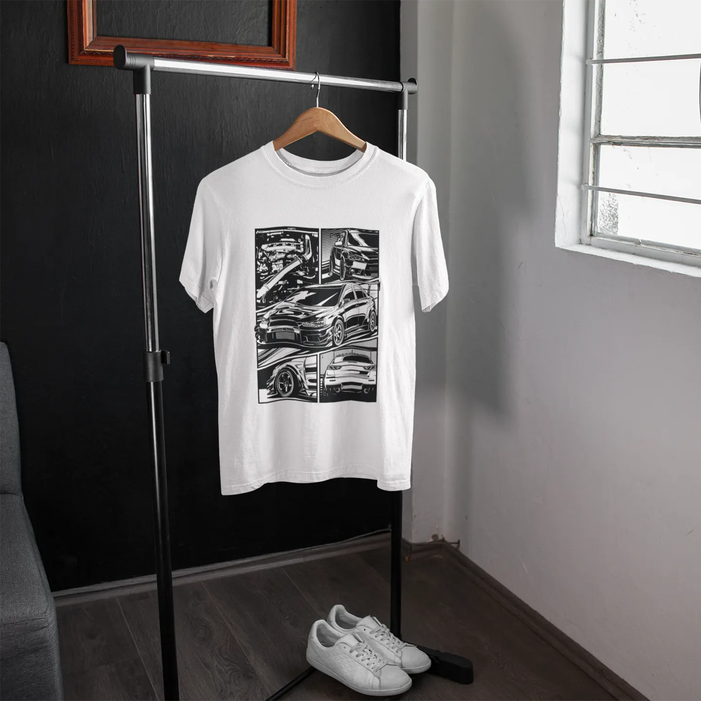 White t-shirt with black graphic design on a hanger against a gray wall.