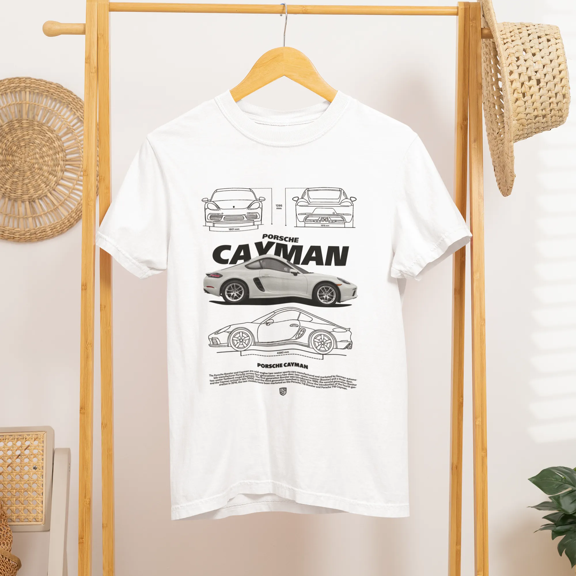 White t-shirt with car design hanging on a wooden rack.