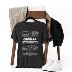 Black t-shirt with Toyota Corolla design on a wooden chair with white sneakers.