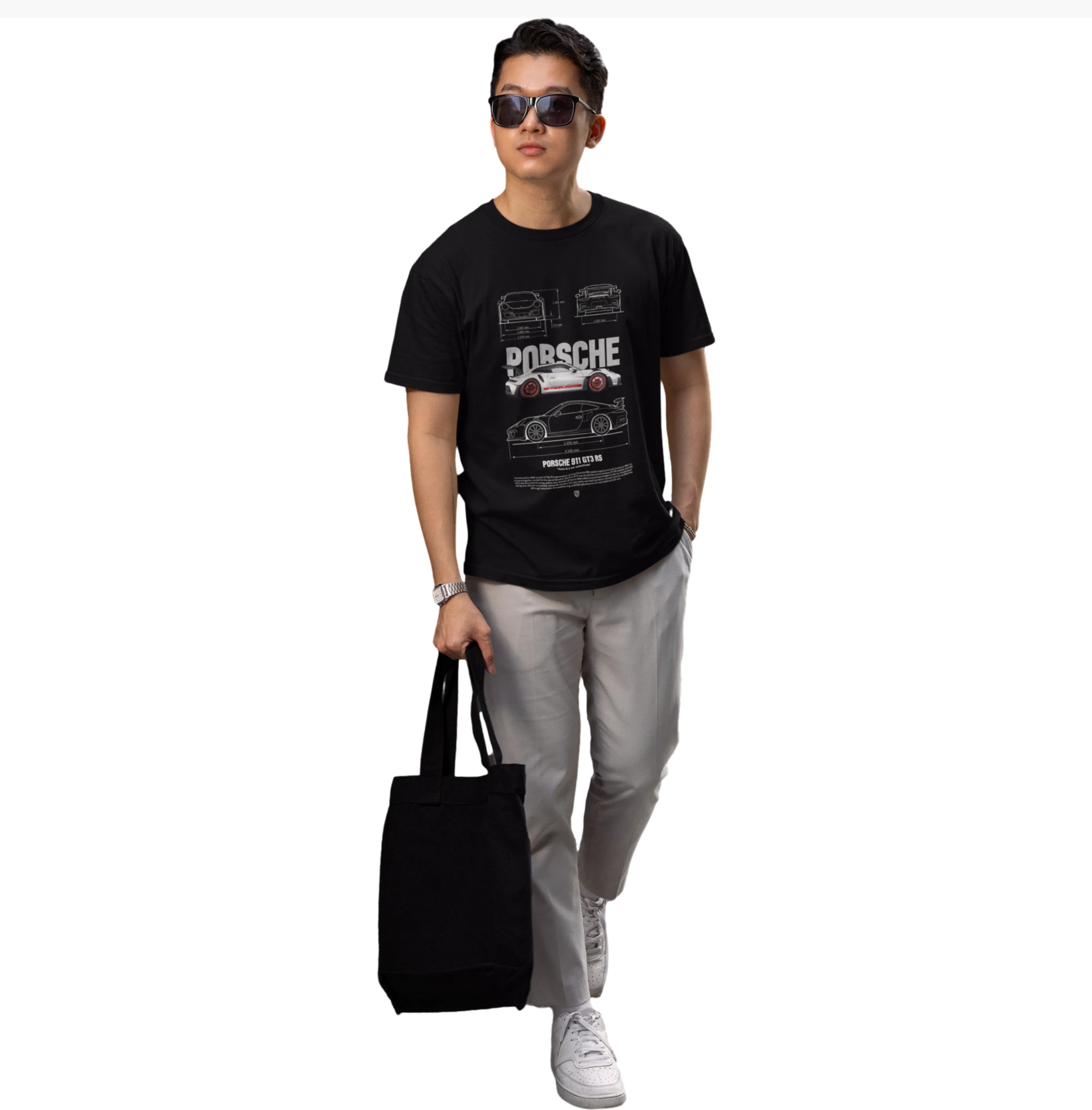 Person wearing a black t-shirt with Porsche design, holding a black bag on a white background