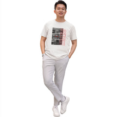 Person wearing a white t-shirt with graphic design and light gray pants on a white background