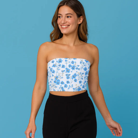 Woman wearing a floral strapless top and black pants on a blue background