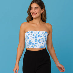 Woman wearing a floral strapless top and black pants on a blue background